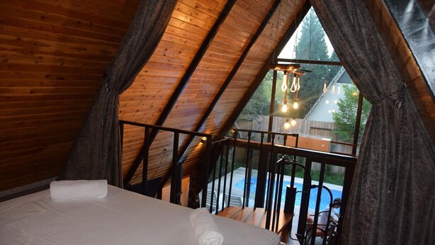 A bedroom with a wooden ceiling and a view of a swimming pool outside. - Big garden sapanca (Sapanca)