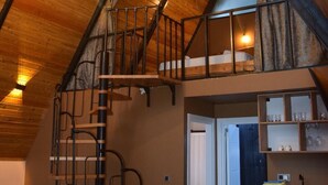 A loft-style room with a wooden ceiling, a spiral staircase, and a kitchen area. - Big garden sapanca (Sapanca)