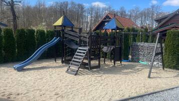 Un parque infantil con tobogán, estructuras para escalar y columpios.
