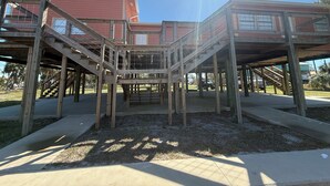 Una estructura de madera de varios niveles con exterior rojo, posiblemente un edificio o una terraza, con escaleras y barandillas visibles.