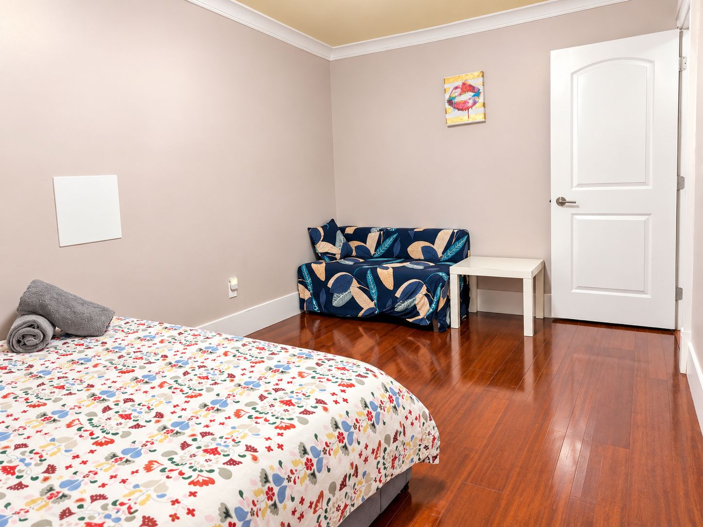 Une chambre à coucher avec un lit, un canapé, une petite table et une porte.