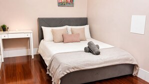 Ein Schlafzimmer mit Bett, Nachttisch und einem Bild an der Wand.