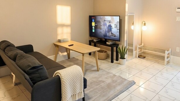 Ein Wohnzimmer mit einer Couch, einem Couchtisch, einem Fernseher und einer Bank.