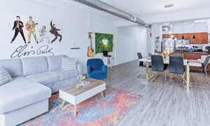 Ein modernes Wohnzimmer mit grauem Sofa, blauem Sessel und Couchtisch.