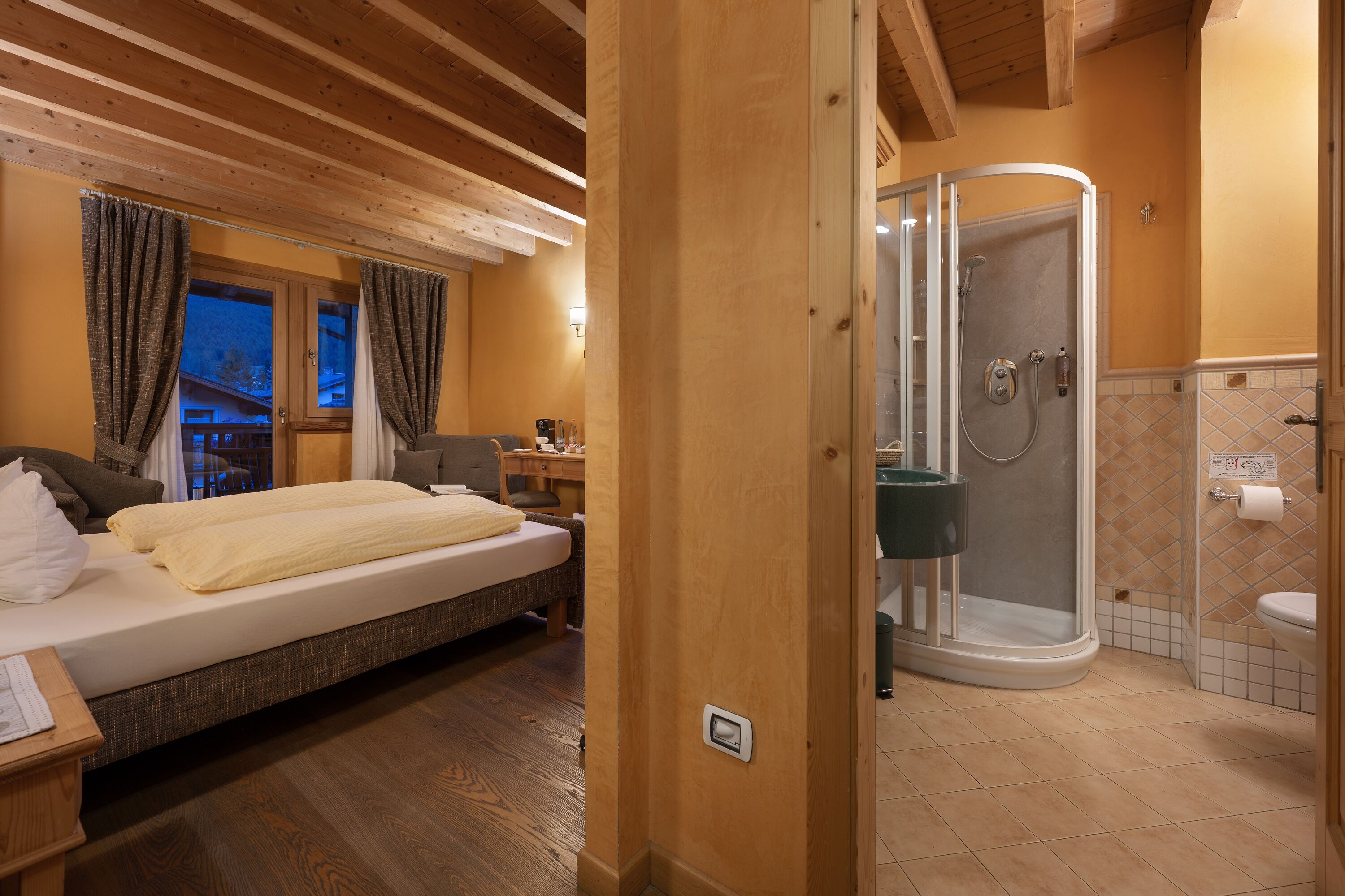 A bedroom with a bed, a nightstand, and a wooden ceiling.