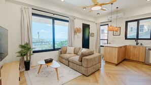 Un salon moderne avec un canapé, une table basse et une vue sur la ville.