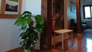 Een houten interieur met een houten bankje, een potplant en een brandblusser.