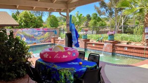 A covered outdoor area with a pool, a table with chairs, and a decorative inflatable ring. - Charming Villa House 3-bedroom with pool & jacuzzi, AC in beautiful San Marcos (San Marcos)