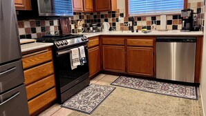 A kitchen with wooden cabinets, a stainless steel stove, a microwave, and a dishwasher. - Charming Villa House 3-bedroom with pool & jacuzzi, AC in beautiful San Marcos (San Marcos)