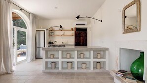 Una cocina moderna con una isla central, estantes empotrados y una chimenea.