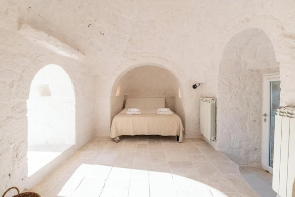 Une chambre à coucher avec un lit, un radiateur et une fenêtre.