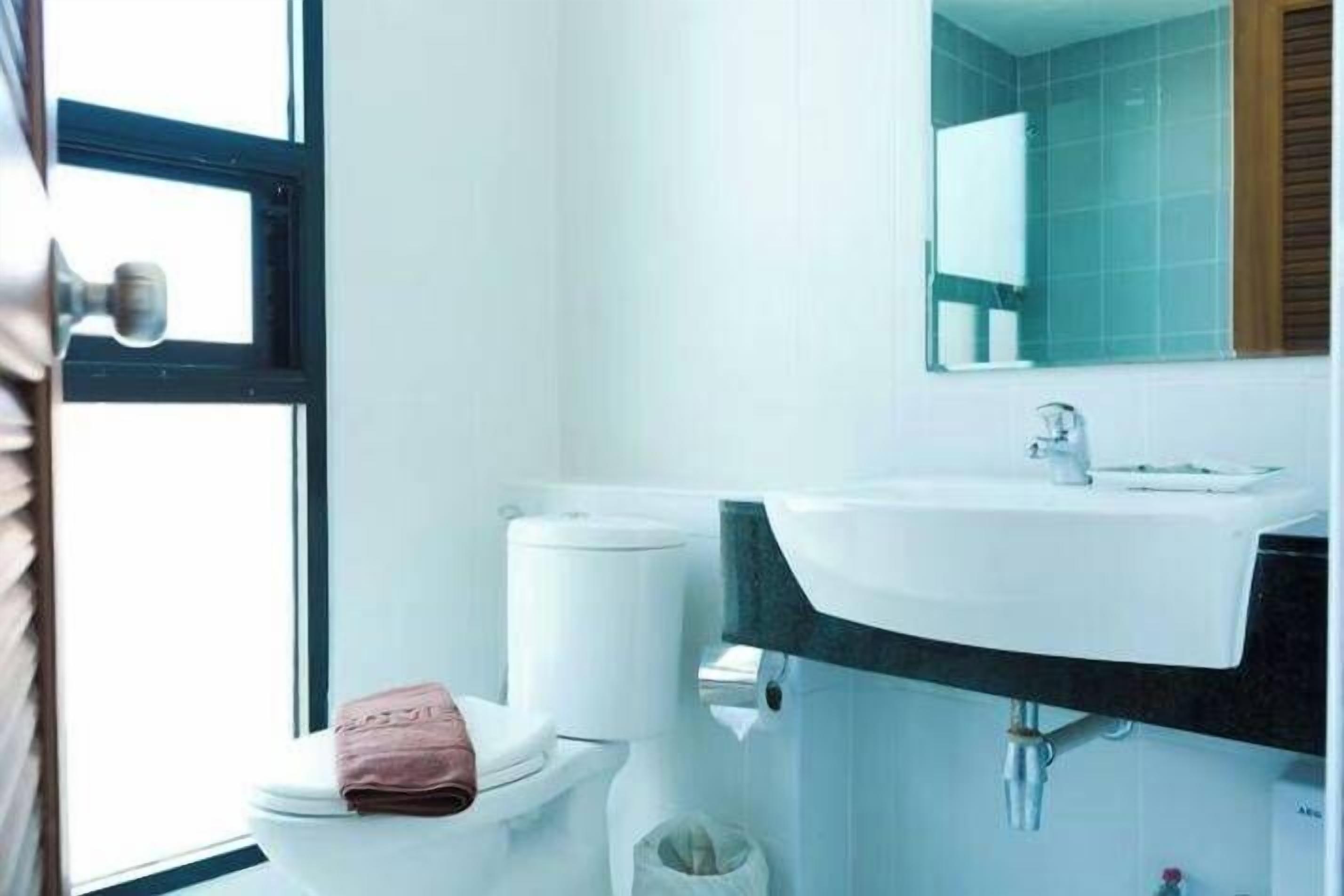 Une salle de bain avec des toilettes, un lavabo et un miroir.