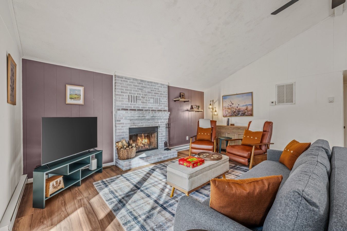 A living room with a fireplace, a flat-screen TV, a sofa, and a coffee table.