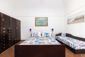 Ein Schlafzimmer mit einem großen Bett, zwei Nachttischen, einem Kleiderschrank und einem Gemälde an der Wand.