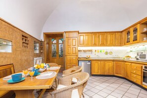 Eine Küche mit Holzausstattung, einem Esstisch mit Stühlen und einer Frühstücksecke.