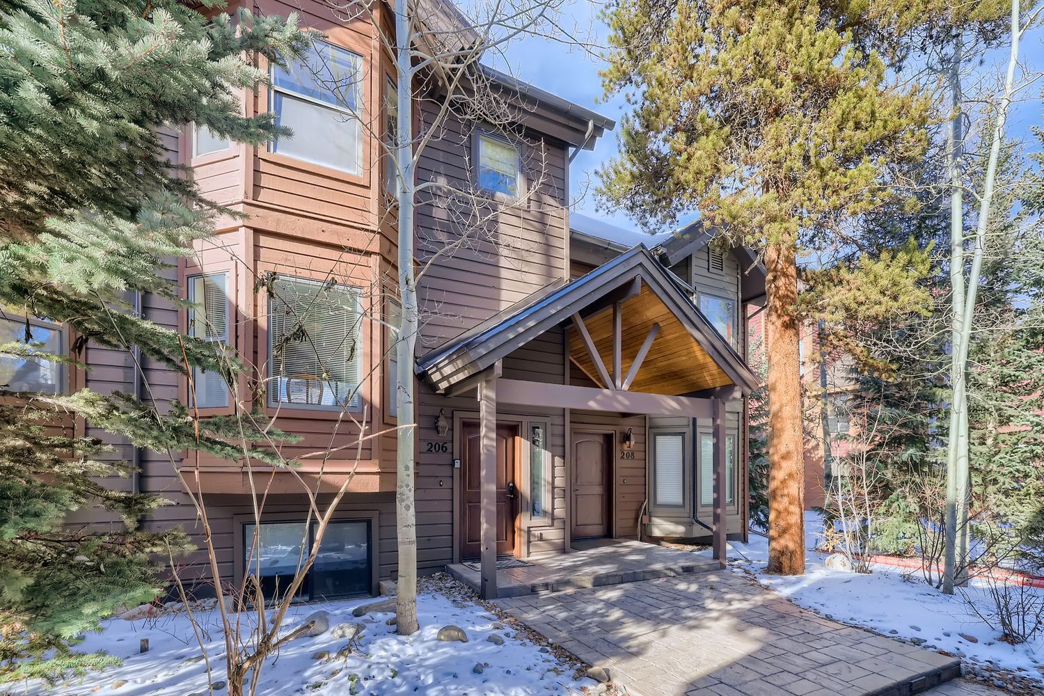 A two-story wooden building with a covered entrance and a snow-covered ground.