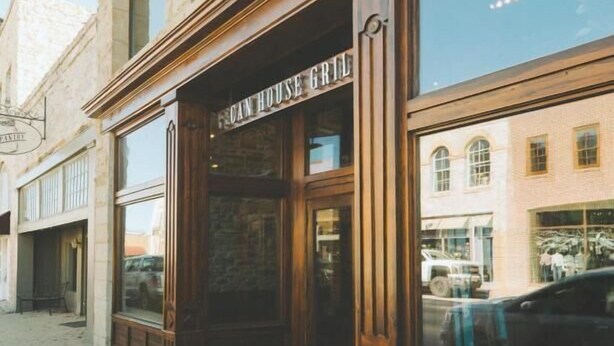 A building with a sign reading "CAN HOUSE GRILL" on the ground floor. - Burnham's Lodging (San Saba)