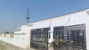 A white building with a black gate and a street lamp.