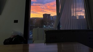 Una stanza con un'ampia finestra, un letto e una televisione.