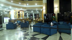 A hotel lobby with a check-in counter, seating area, and a staircase. - Tropical Executive Suíte Flat 1001 | Ponta Negra | (Manaus)