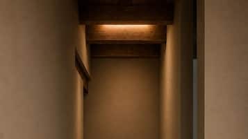 A narrow hallway with a wooden ceiling and a light fixture.