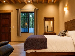 A bedroom with a wooden bed, a nightstand, a mirror, and a window with curtains.