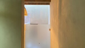 Ein schmaler Korridor mit Holzboden und einer Tür am Ende.