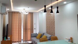 A modern living room with a dining area, featuring a sofa, a coffee table, and a dining table with chairs. - Unit 706-One Bedroom Unit at One Pontefino Tower (Batangas City)