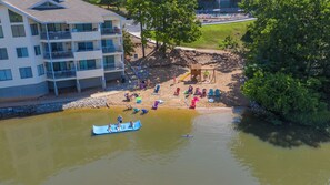 A riverside area with a dock, boats, and people engaging in water activities.