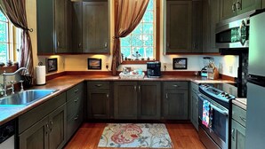 A kitchen with dark cabinets, a wooden ceiling, and a chandelier. - Hidden Gem in the Smokies - Awenasa (Franklin)