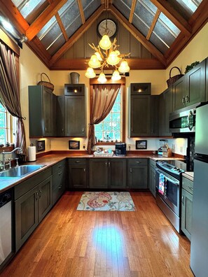 A kitchen with dark cabinets, a wooden ceiling, and a chandelier. - Hidden Gem in the Smokies - Awenasa (Franklin)