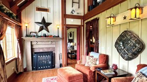 A spacious living room with a fireplace, a ceiling fan, and a view of the upper floor. - Hidden Gem in the Smokies - Awenasa (Franklin)
