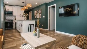 A modern kitchen with white cabinets, a central island, and pendant lighting. - Charming Detached Bungalow in Historic Old Town Monrovia Kingsize Bed！ (Monrovia)