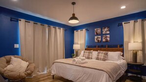 A bedroom with a large bed, two bedside tables with lamps, a chair, and curtains. - Charming Detached Bungalow in Historic Old Town Monrovia Kingsize Bed！ (Monrovia)