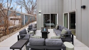 Eine moderne Außenpatio mit einer Couch, Stühlen und einem Tisch.