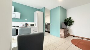 A modern kitchen with white cabinets, a microwave, and a coffee maker. - L'Ostro - Civitanova Marche, new two-room apartment in a strategic location (Civitanova Marche)