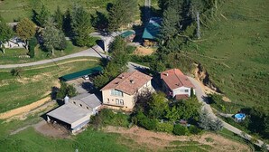 A rural house with a large barn, surrounded by green fields and trees. - Turisme Rural El Janpere - La Cabanya (Sant Joan de les Abadesses)