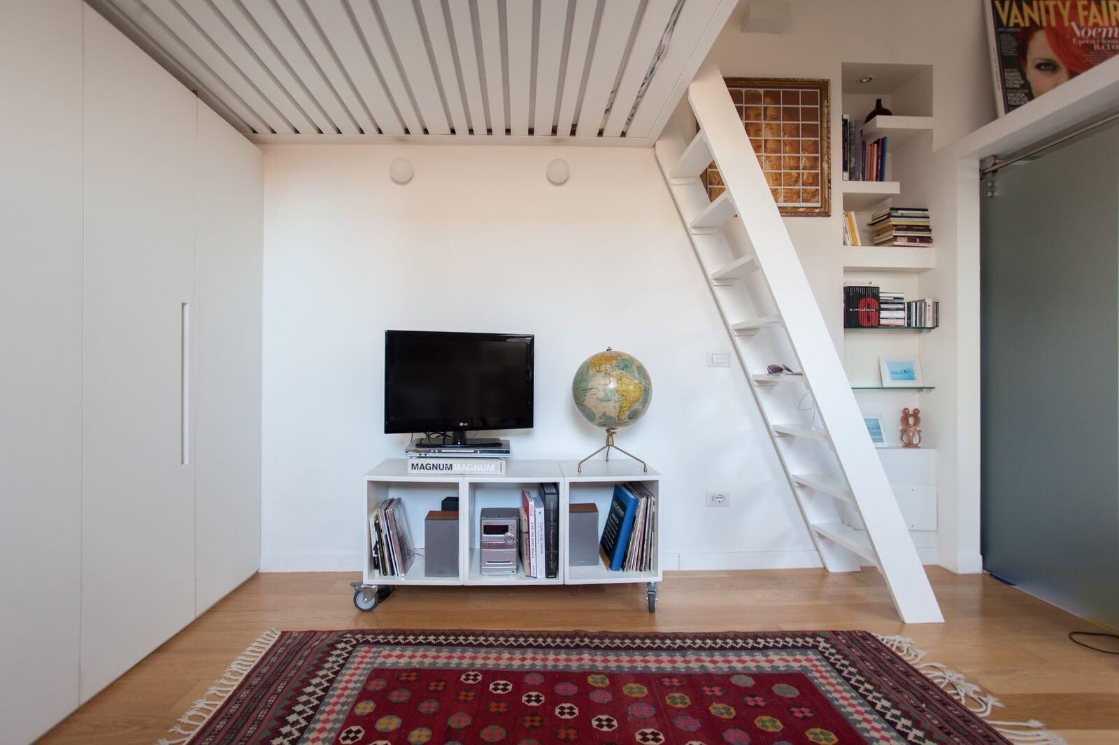 Un salon moderne avec un téléviseur à écran plat, un globe terrestre et une bibliothèque.