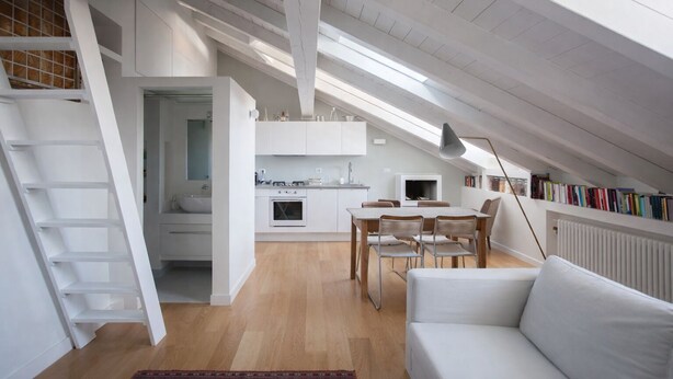 Ein modernes Loft-Apartment mit Küche, Essbereich und einer gemütlichen Sitzecke.