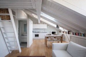 Ein modernes Loft-Apartment mit Küche, Essbereich und einer gemütlichen Sitzecke.