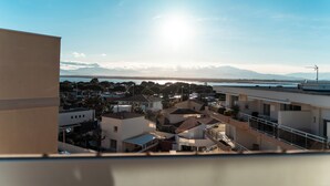 A residential area with modern buildings, a clear sky, and distant mountains. - Terrasses Catalanes Sea&Mountain View near the beach & private parking (Canet-en-Roussillon)