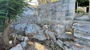 A stone wall with a wooden staircase leading up. - Ostuni Green Hills Apt. 1 – Charming Home with Panoramic View & Shared Jacuzzi (Puglia)