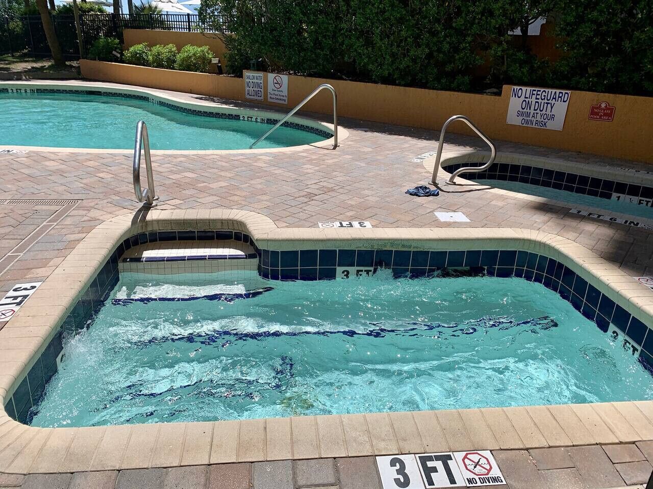 Une piscine avec un panneau indiquant qu’il est interdit de plonger, un panneau indiquant la présence d’un sauveteur et un indicateur de profondeur indiquant 3 pieds.