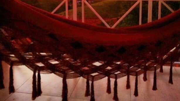 A hammock on a balcony with a view of a sunset over a hilly landscape. - Complete house with a beautiful view of nature. (Bananal)
