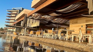 Un hôtel situé au bord de l’eau, doté d’une terrasse, d’une piscine et d’une architecture moderne.