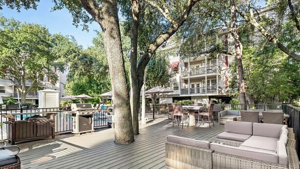 Une terrasse avec des meubles d’extérieur, un barbecue et une piscine.