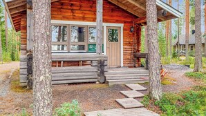 A log cabin with a porch, large windows, and a door. - Luhtalemmikki by Interhome (Lieksa)