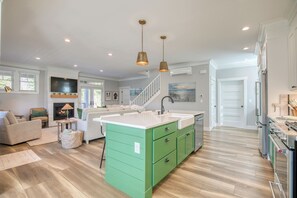 A modern kitchen with a green island, white countertops, and stainless steel appliances. - NEW! 10 min. Walk to Town & Beach, PVT Hot Tub + Fenced Yard, Bikes, Fire-pit (Pacific Beach)