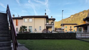 Un barrio residencial con un césped cuidado, un sendero pavimentado y casas con balcones.