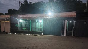 A building with a gated entrance, a paved driveway, and a metal fence. - Apartment with access to the beach, a place to stroll beautiful experience. (Quepos)